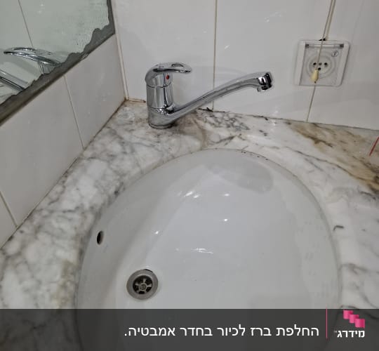 ברז כרום מותקן על כיור שיש לבן